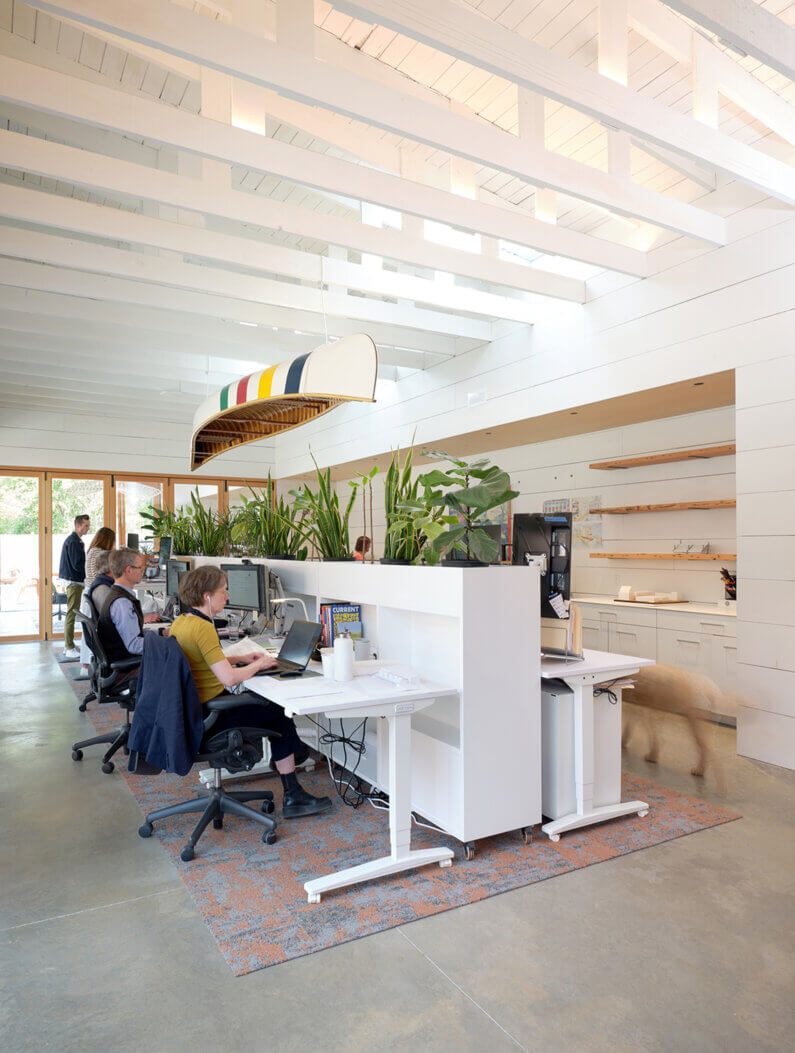 an interior workspace with a canoe tethered to the exposed trusses