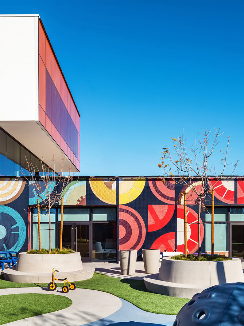 Exterior of a clinic with a bright mural and playground