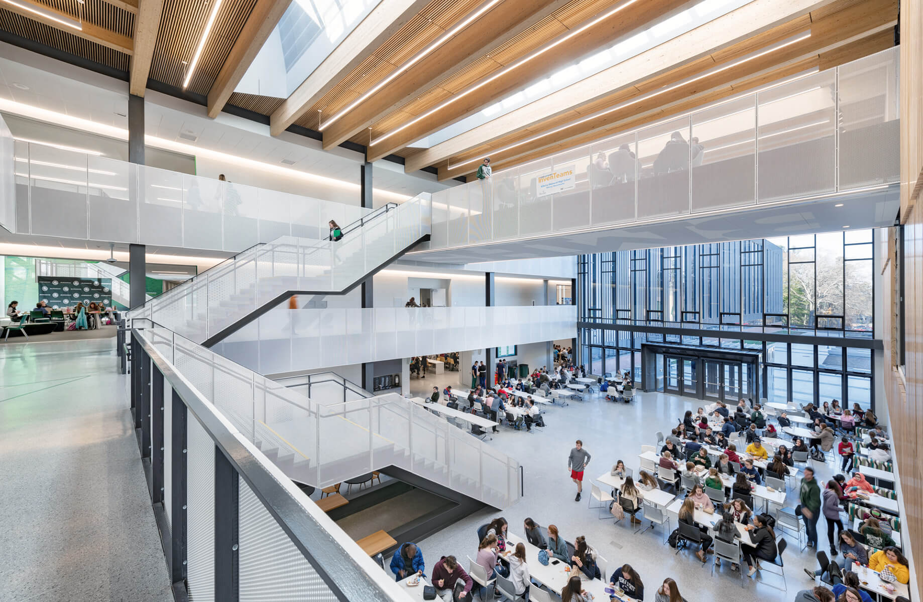 the atrium of a high school with student seated at tables