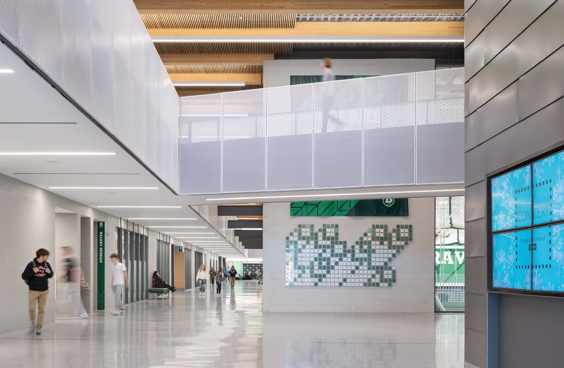 a high-ceilinged hallway in a high school with walkways above