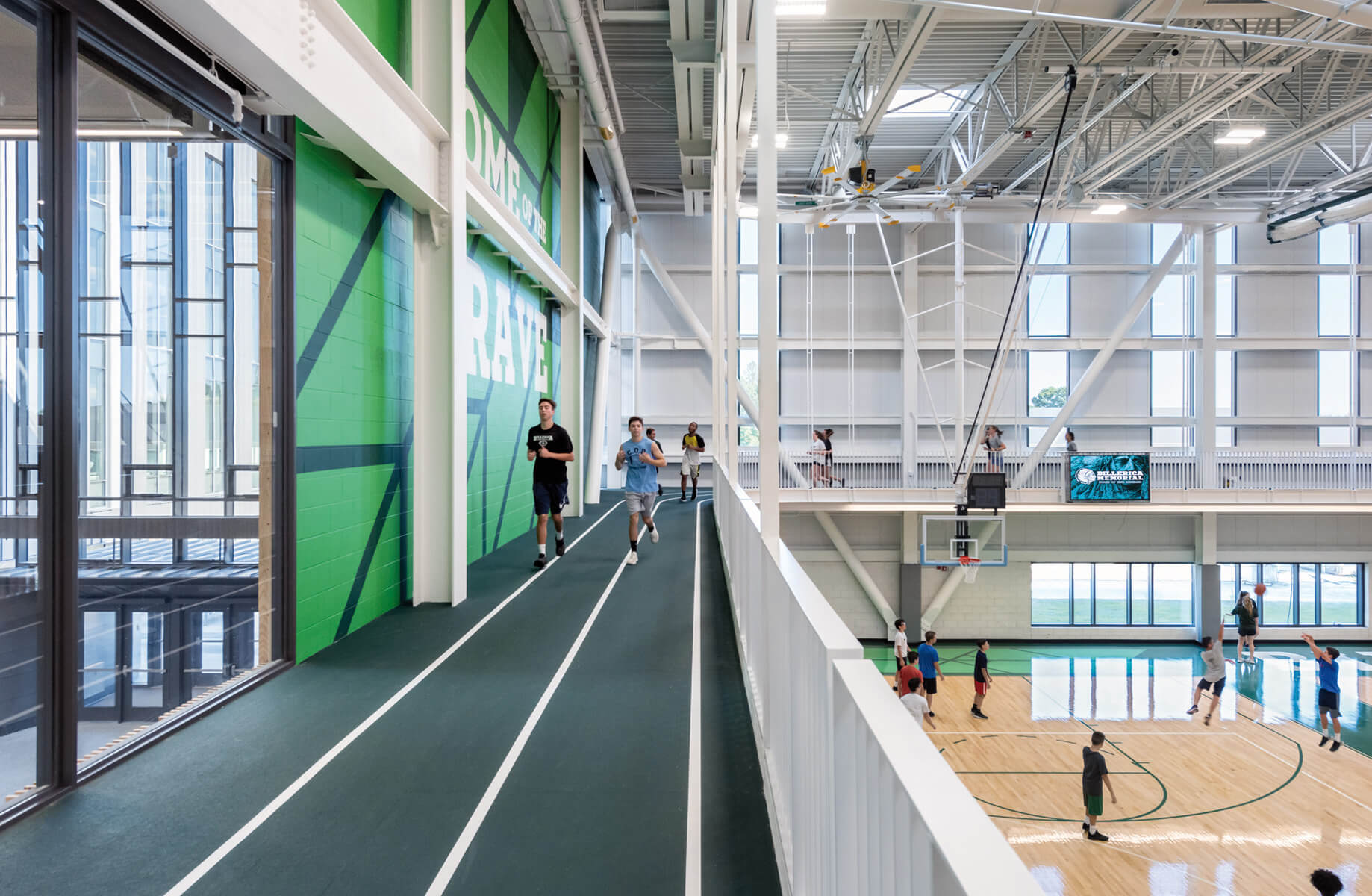 a large high school gymnasium with a suspended track around a basketball court