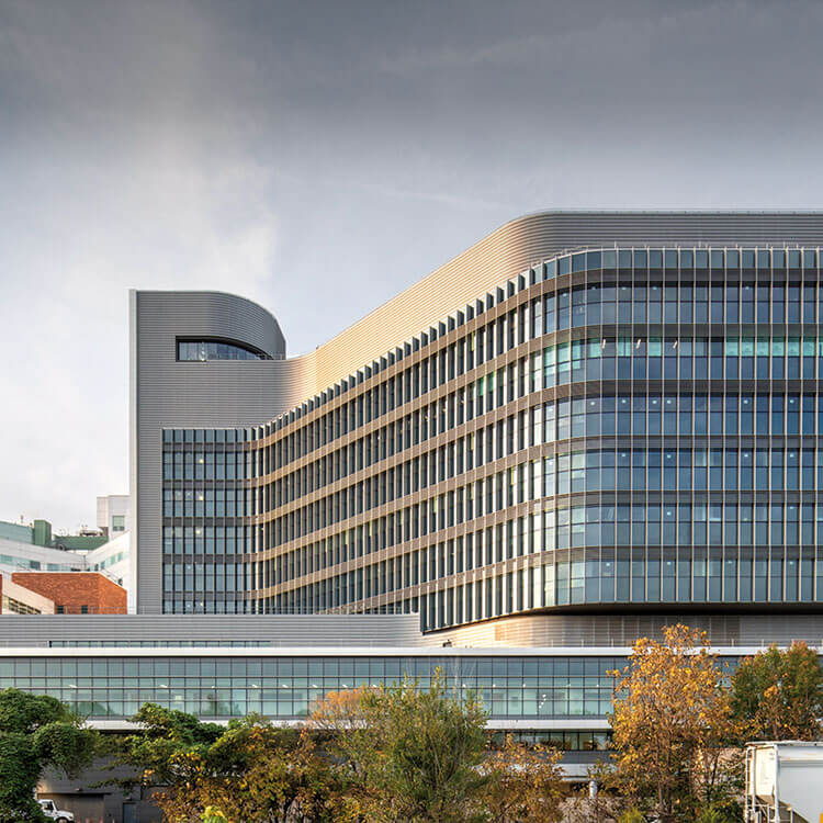 an exterior of a glass hospital building on a plinth