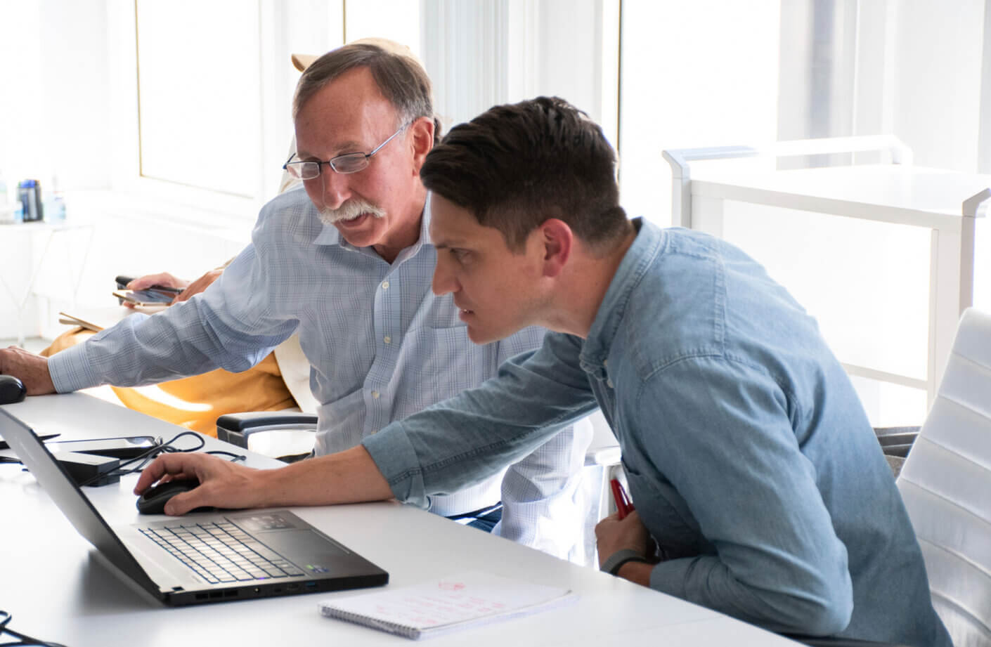 people collaborating looking at laptop