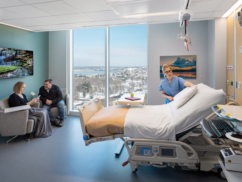 patient room n hospital with nurse and visitors sitting