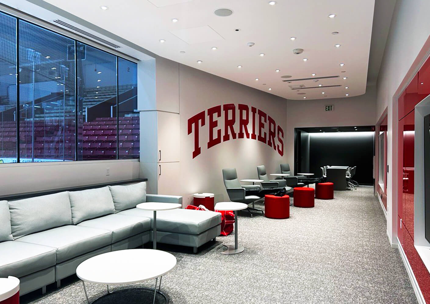 Women's ice hockey locker room with seating and view to ice rink