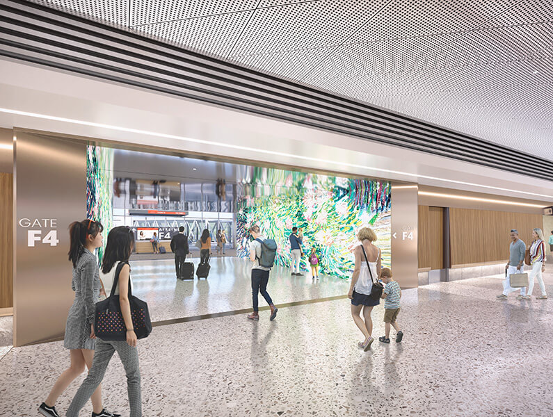 A rendering of a passageway in Terminal F illuminated by floor-to-ceiling digital displays on each wall