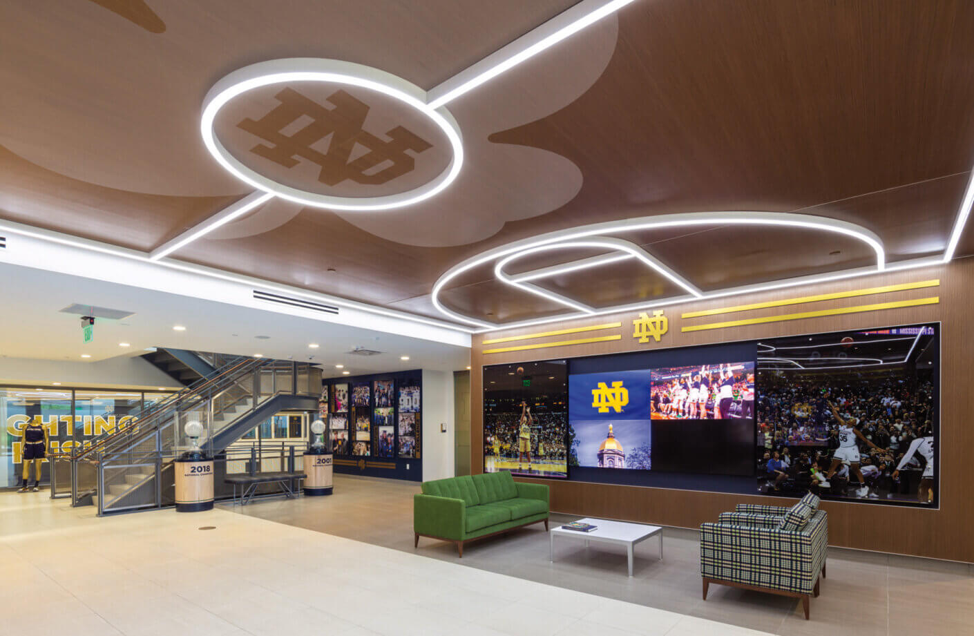 Lobby of basketball arena with bright lighting, wood, and branding