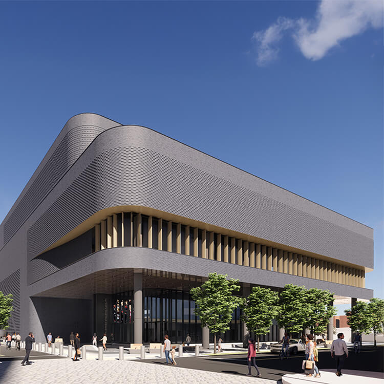 exterior of gray brick sports building on a busy city street