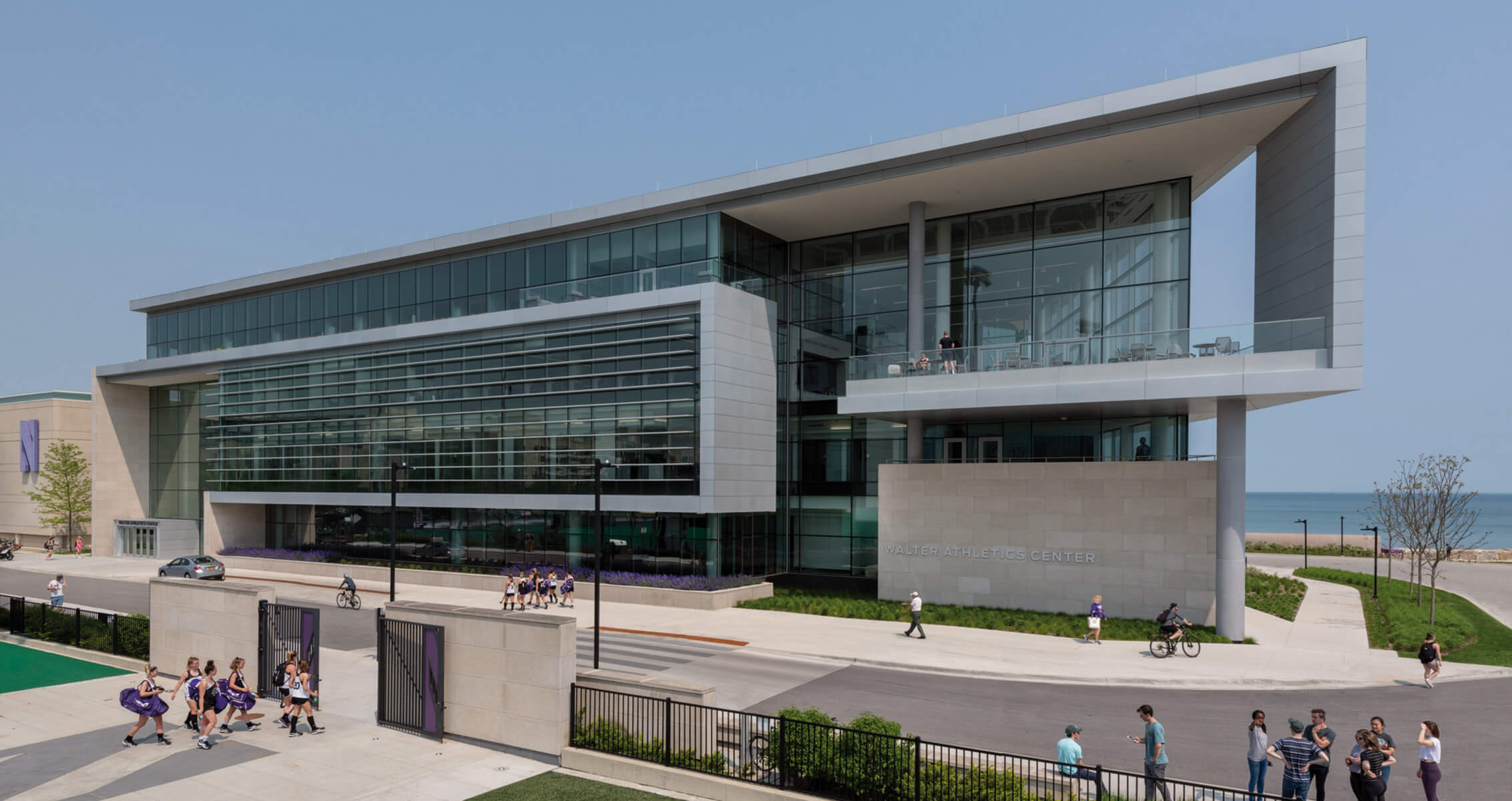 Exterior of sports and recreation building with people walking around sidewalks