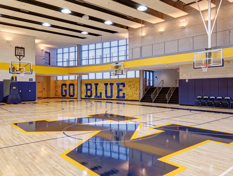 Basketball practice court space with windows and blue / yellow branding