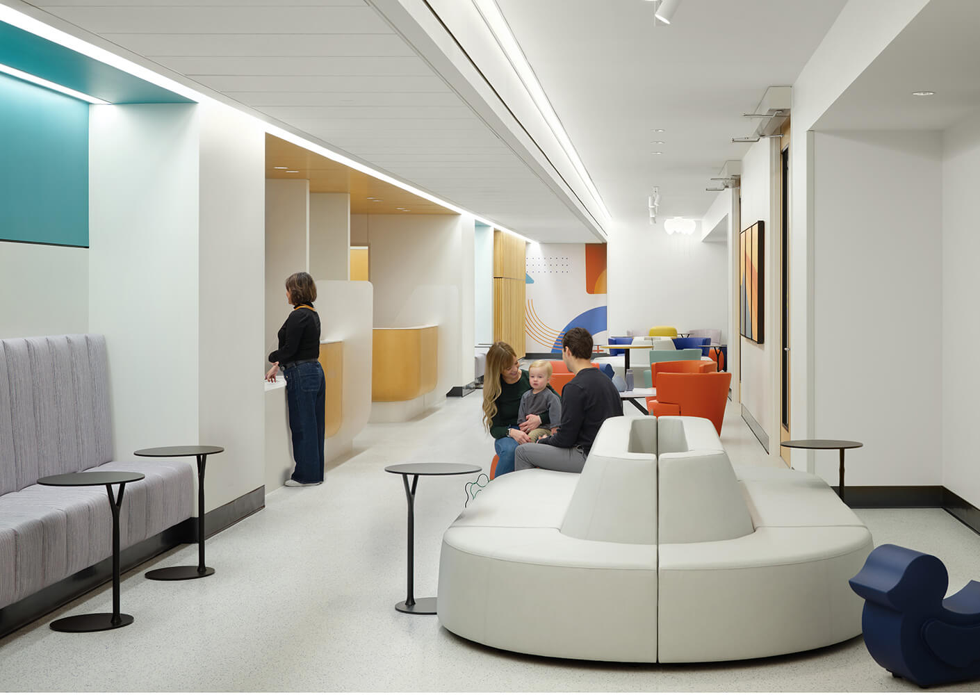 Modern reception area with colorful seating and people interacting.