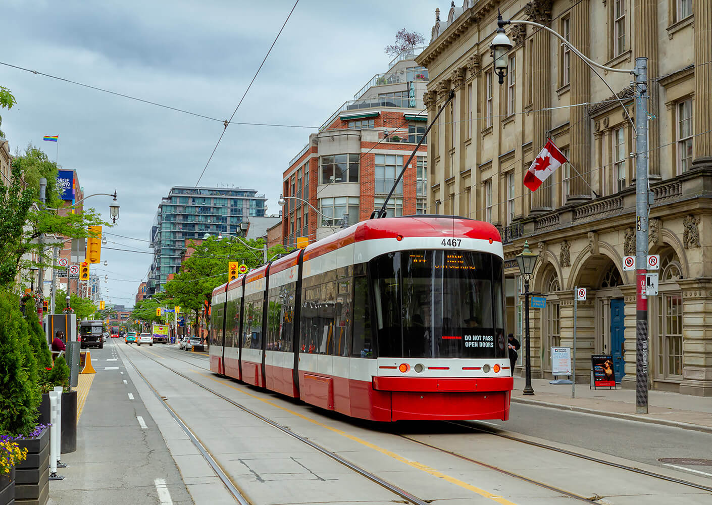 A red streetcar travelling down a street in Toronto