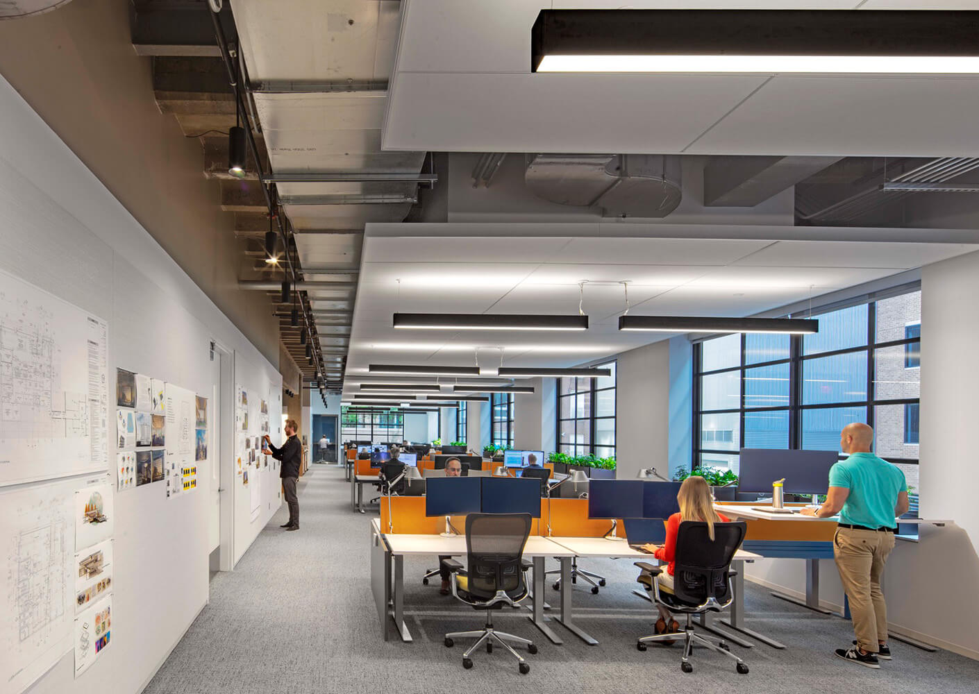 Open office with workstations and people collaborating