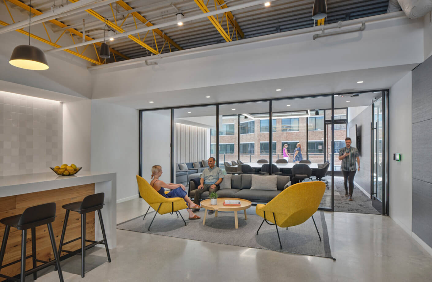 people sitting in a lounge with windows to roof deck outside