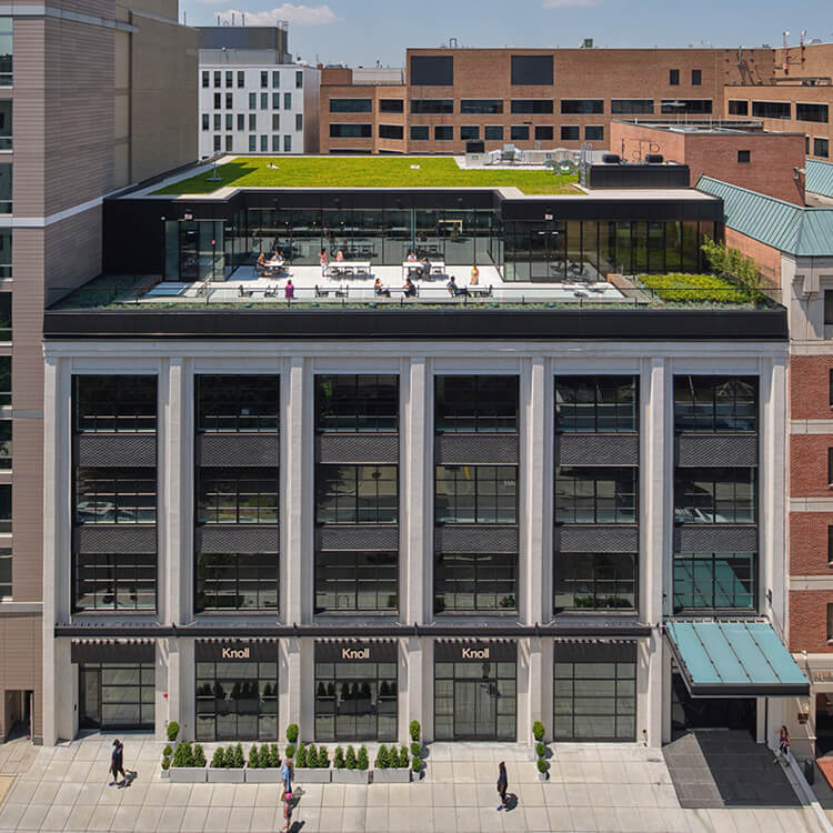 Aerial drone image showing exterior of industrial city buildings with people walking on street