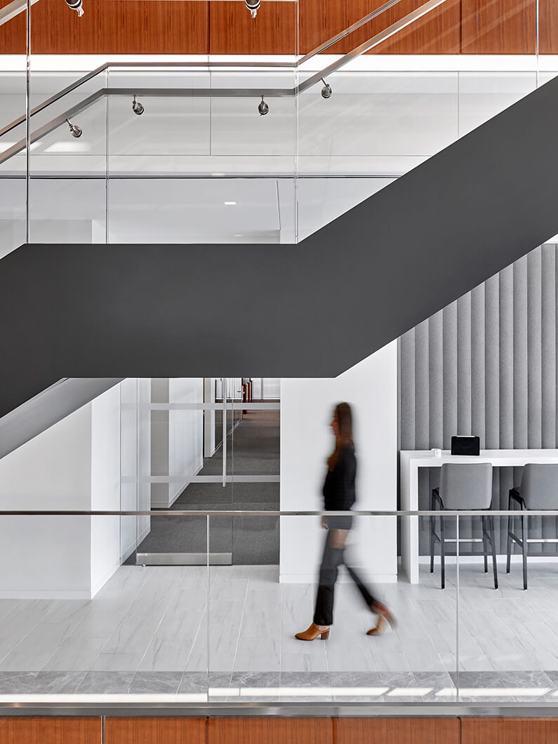 person walking in an office with a grand interconnecting stair