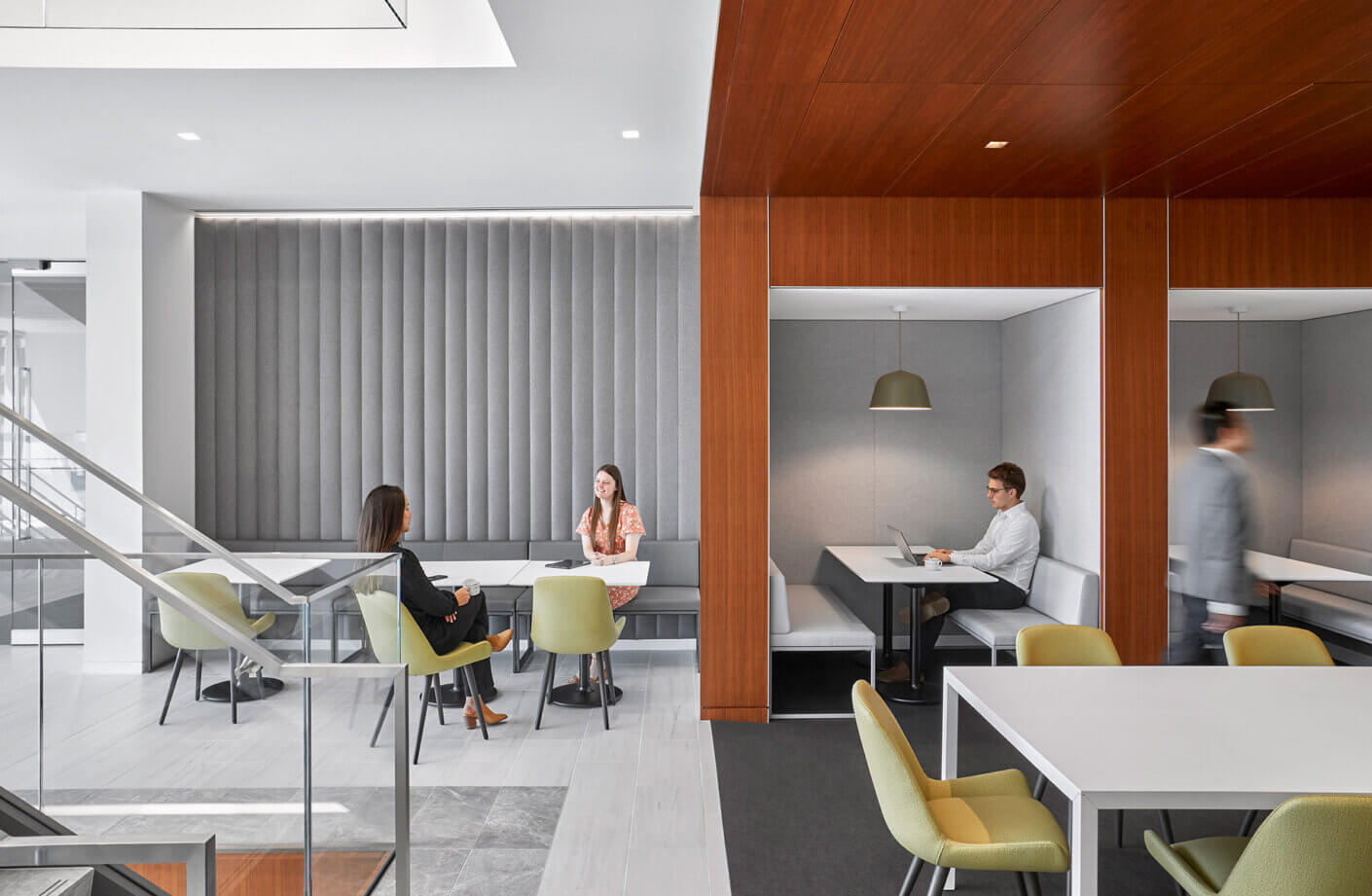 Work cafe with a person working privately and two people talking at a table
