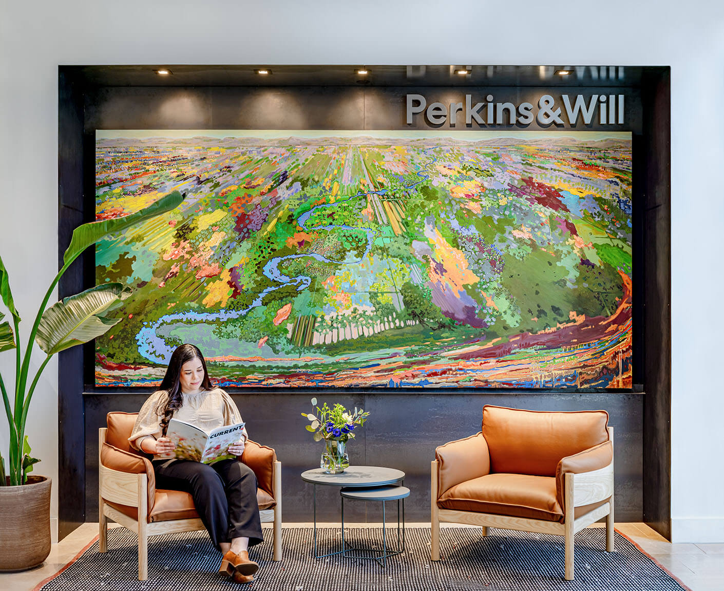 A brightly colored abstract mural evokes water, fauna, and natural resources and of the San Antonio landscape. It is mounted on the wall behind an entryway seating area