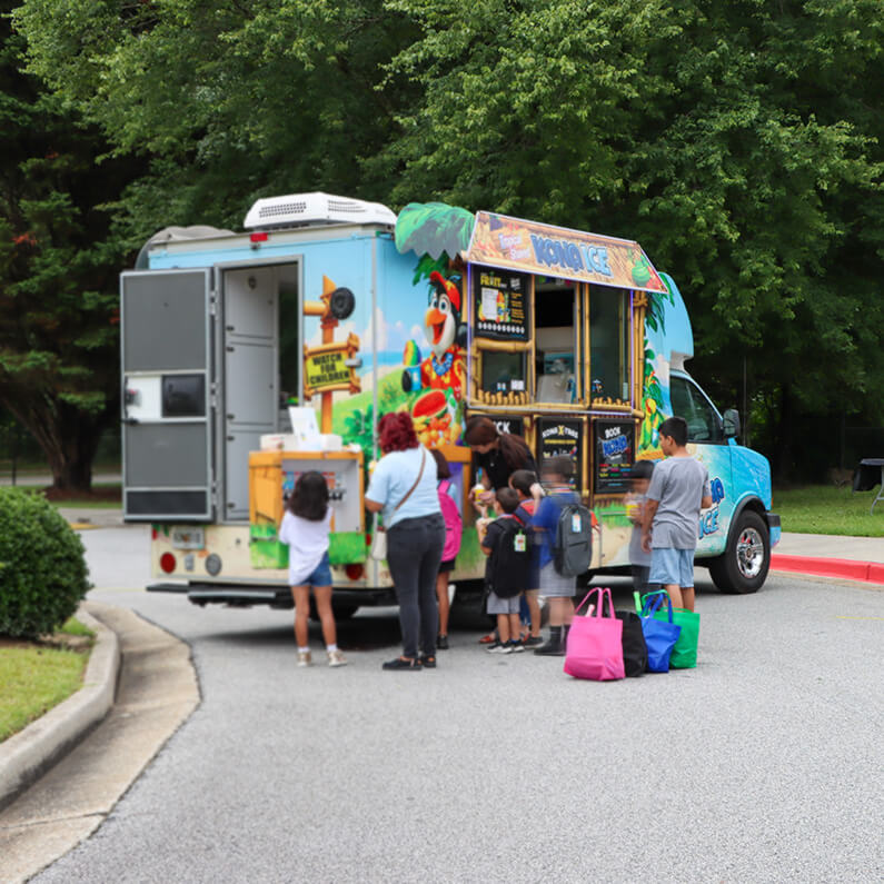 students in front of a snow cone truck