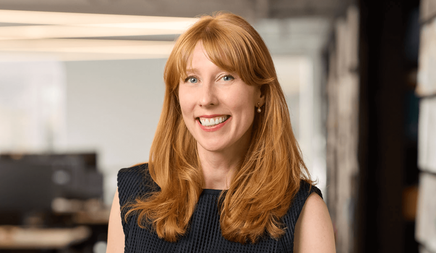 Woman smiling in office setting looking directly at camera