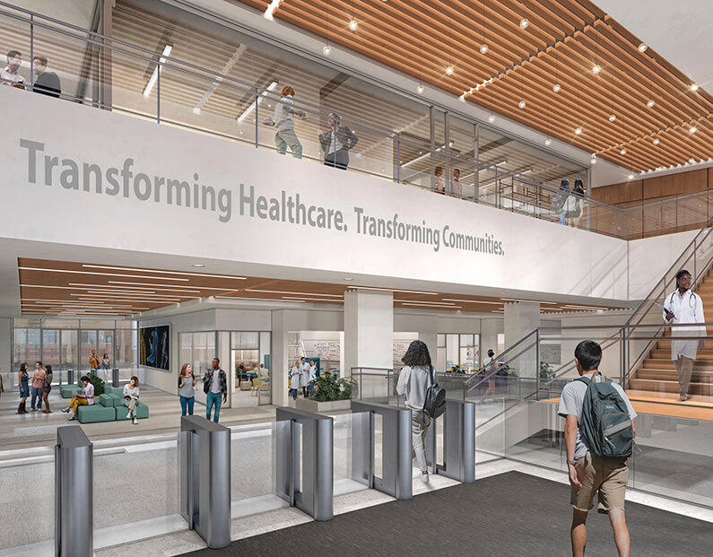 Modern healthcare facility lobby with people and a sign saying Transforming Healthcare. Transforming Communities.