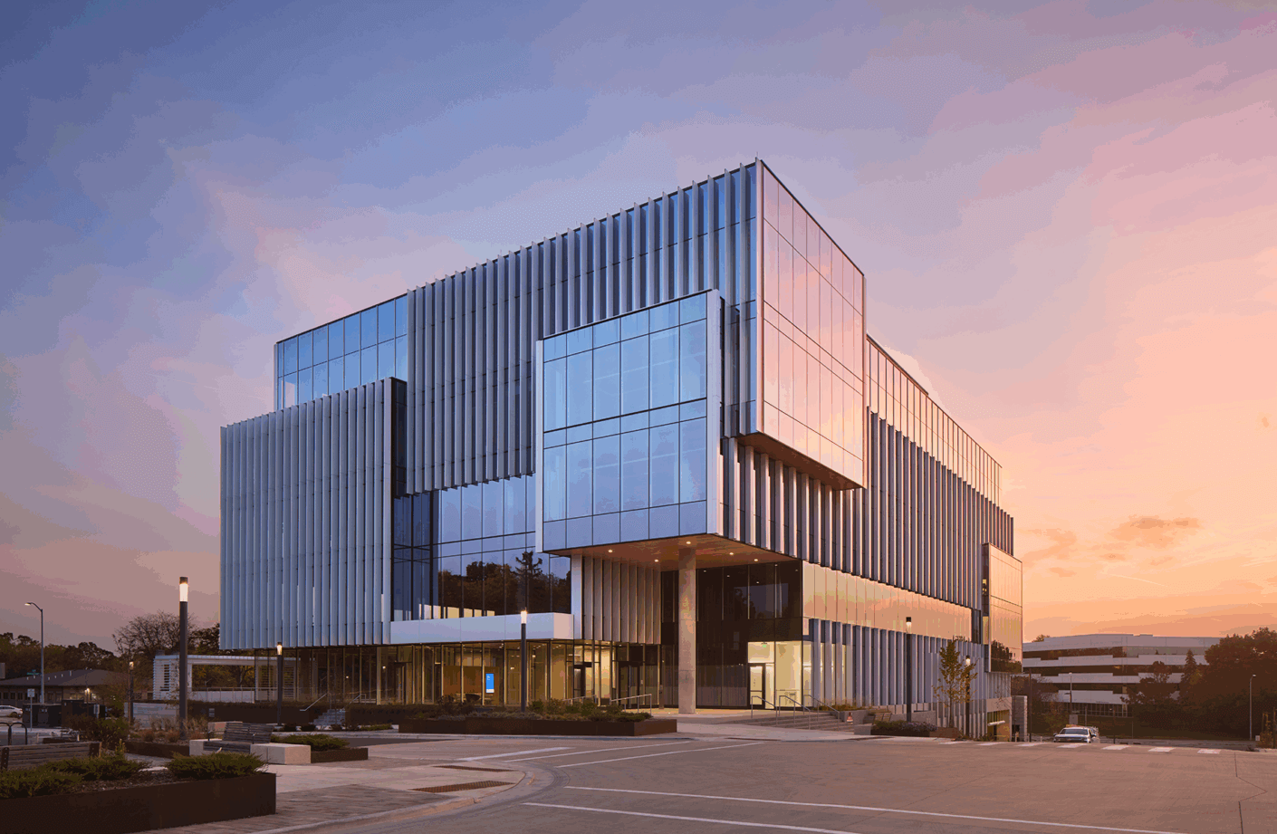 Modern glass building at sunset with sleek architectural design.