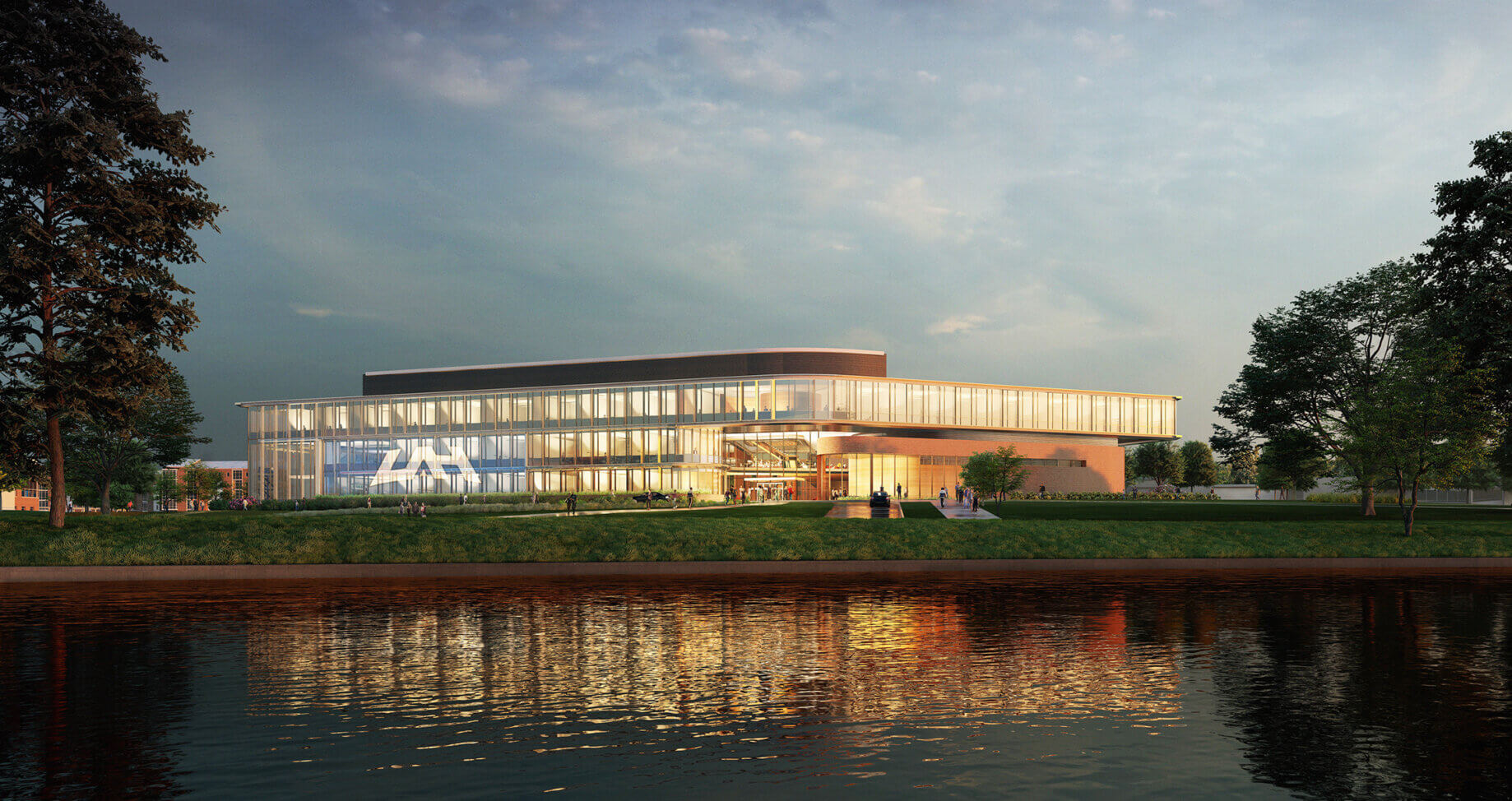 Modern glass building surrounded by greenery and reflecting on a tranquil river at dusk.