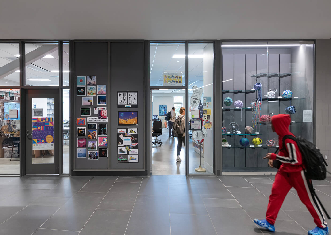 Art classroom entrance featuring student artwork display and passing students.