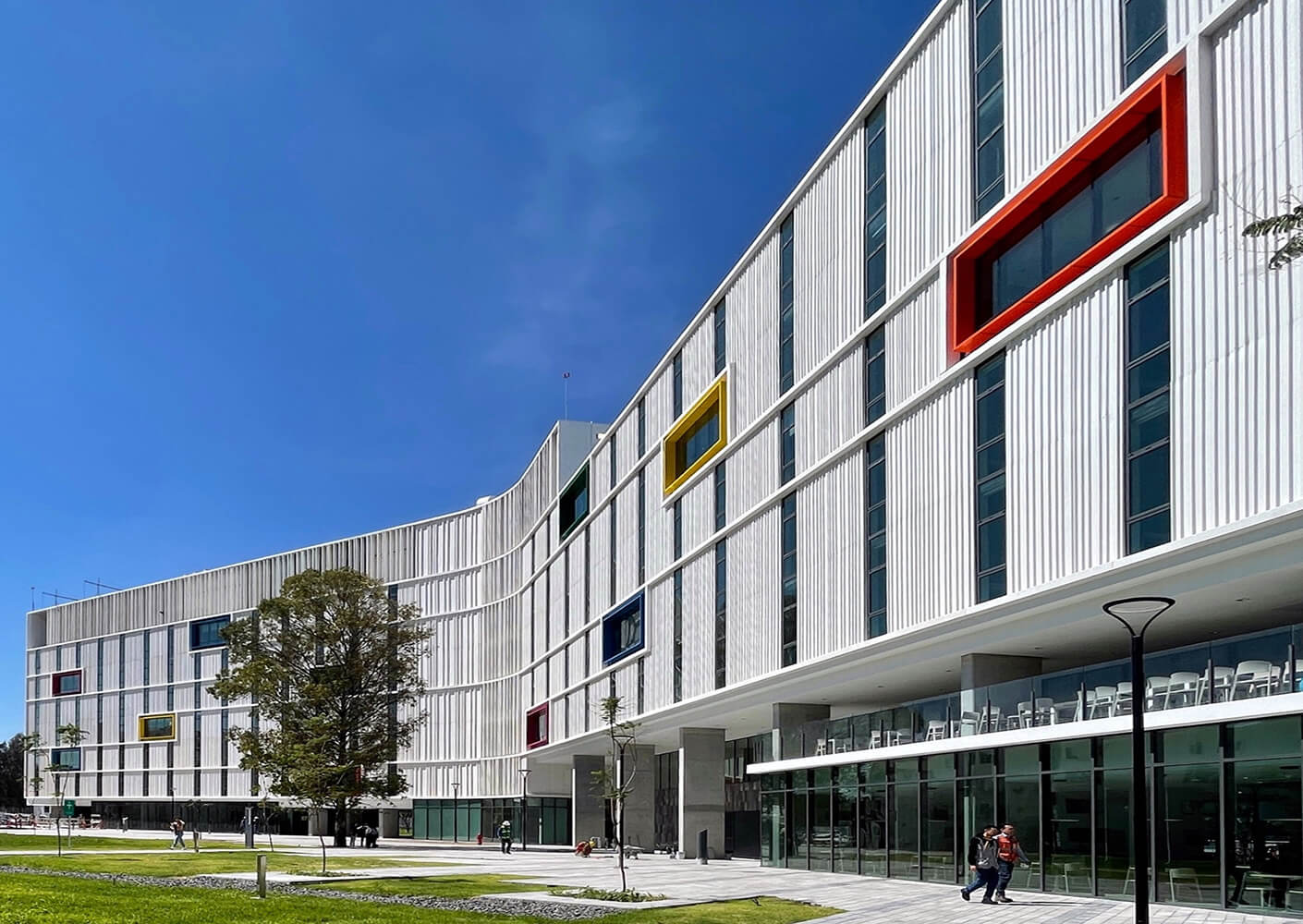 Modern building with colorful windows under a clear blue sky.
