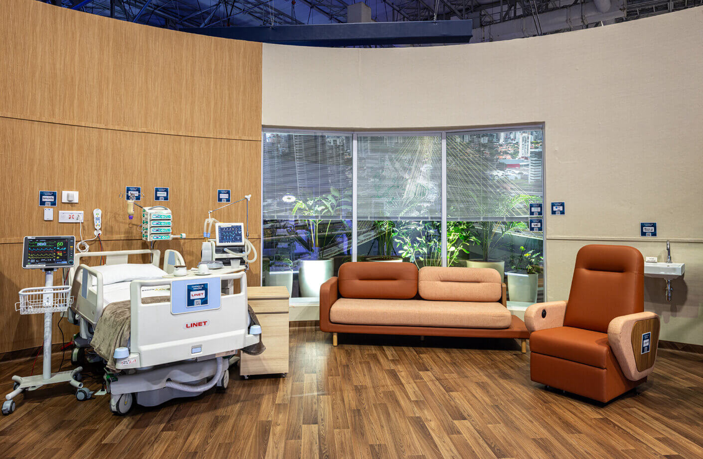 Modern hospital room with an adjustable bed and comfortable seating.