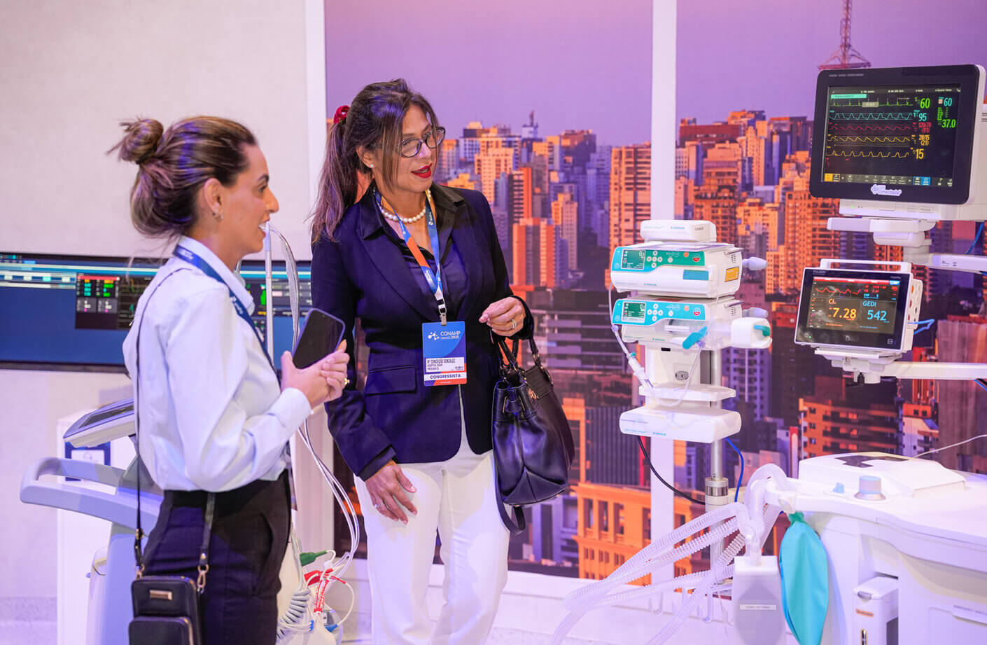 Healthcare professionals explore medical equipment at a conference exhibit.