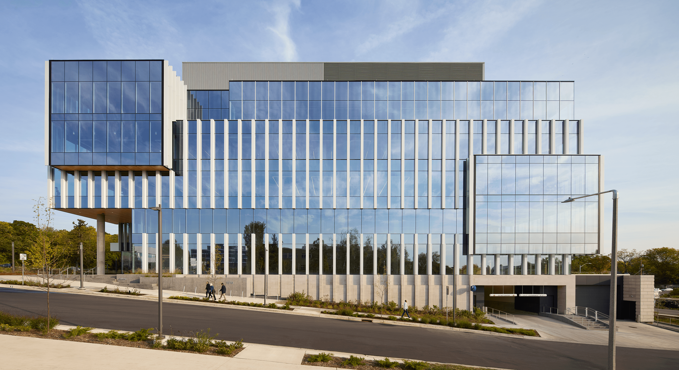 Modern glass office building under blue sky.