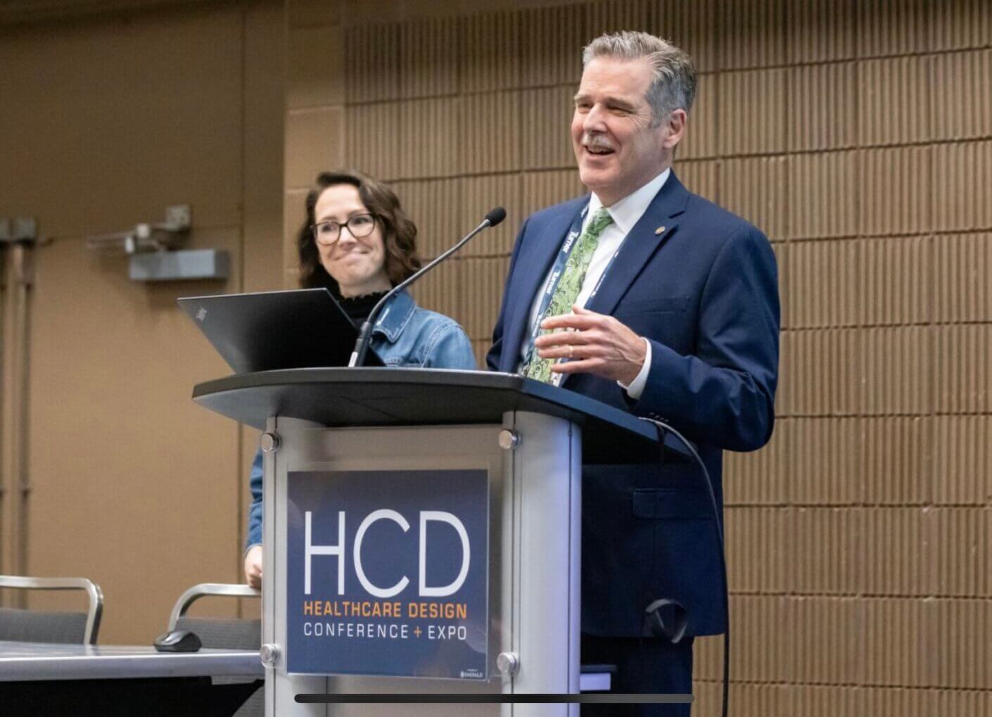 Speakers at Healthcare Design Conference podium.