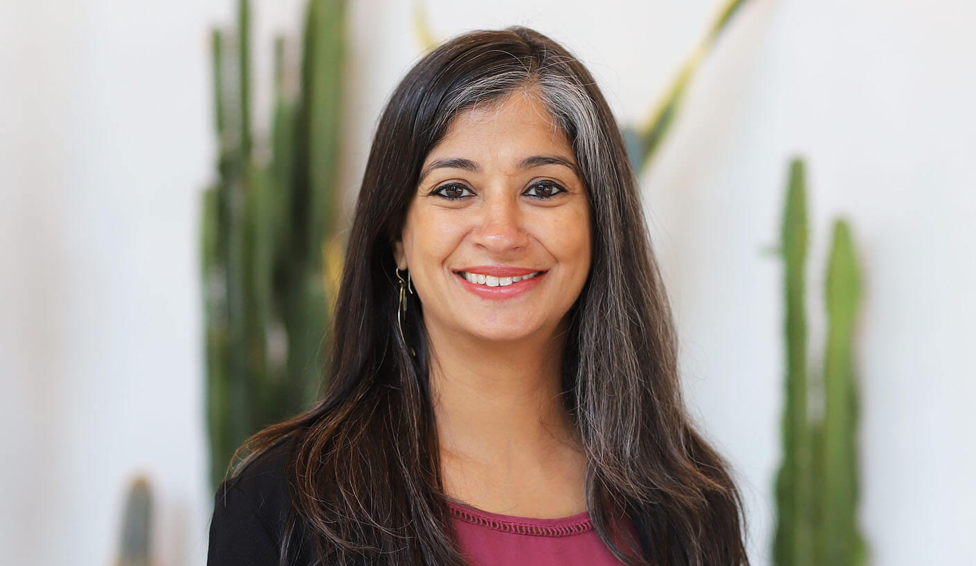 Woman smiling against white background with cacti