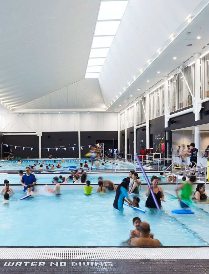 Indoor swimming pool with people enjoying activities and lessons.