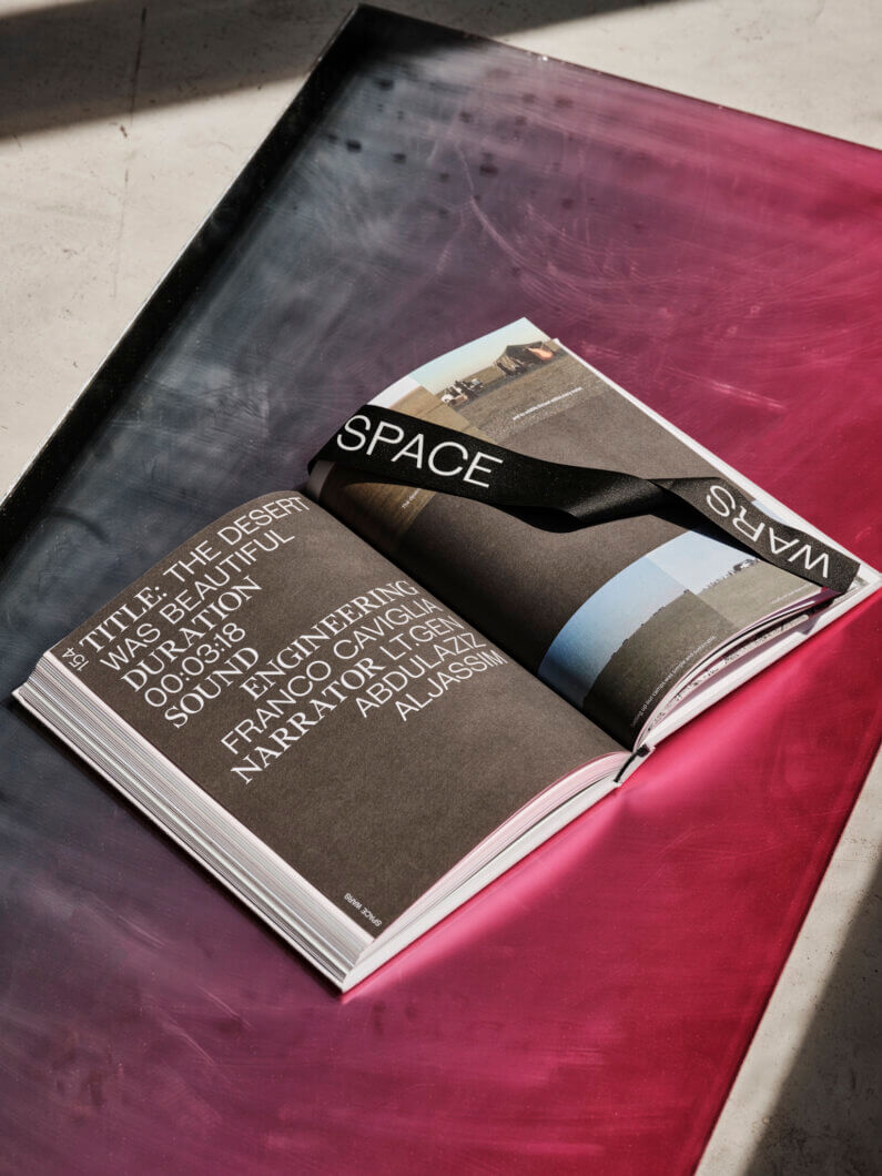 Open book with black ribbon, pinkish surface in sunlight.