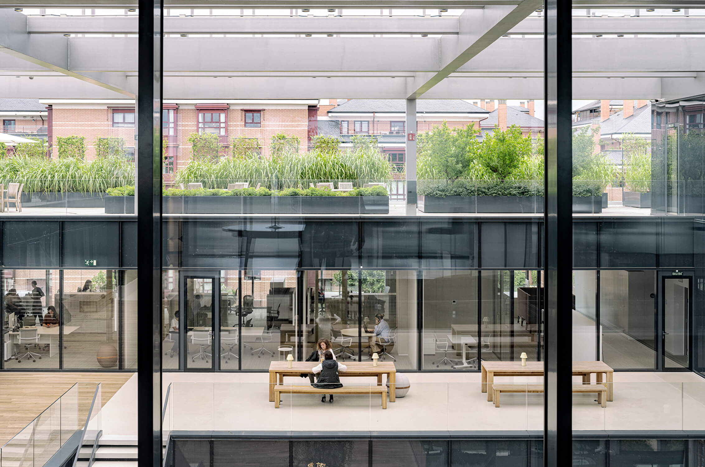 Modern office building with rooftop garden and glass windows.
