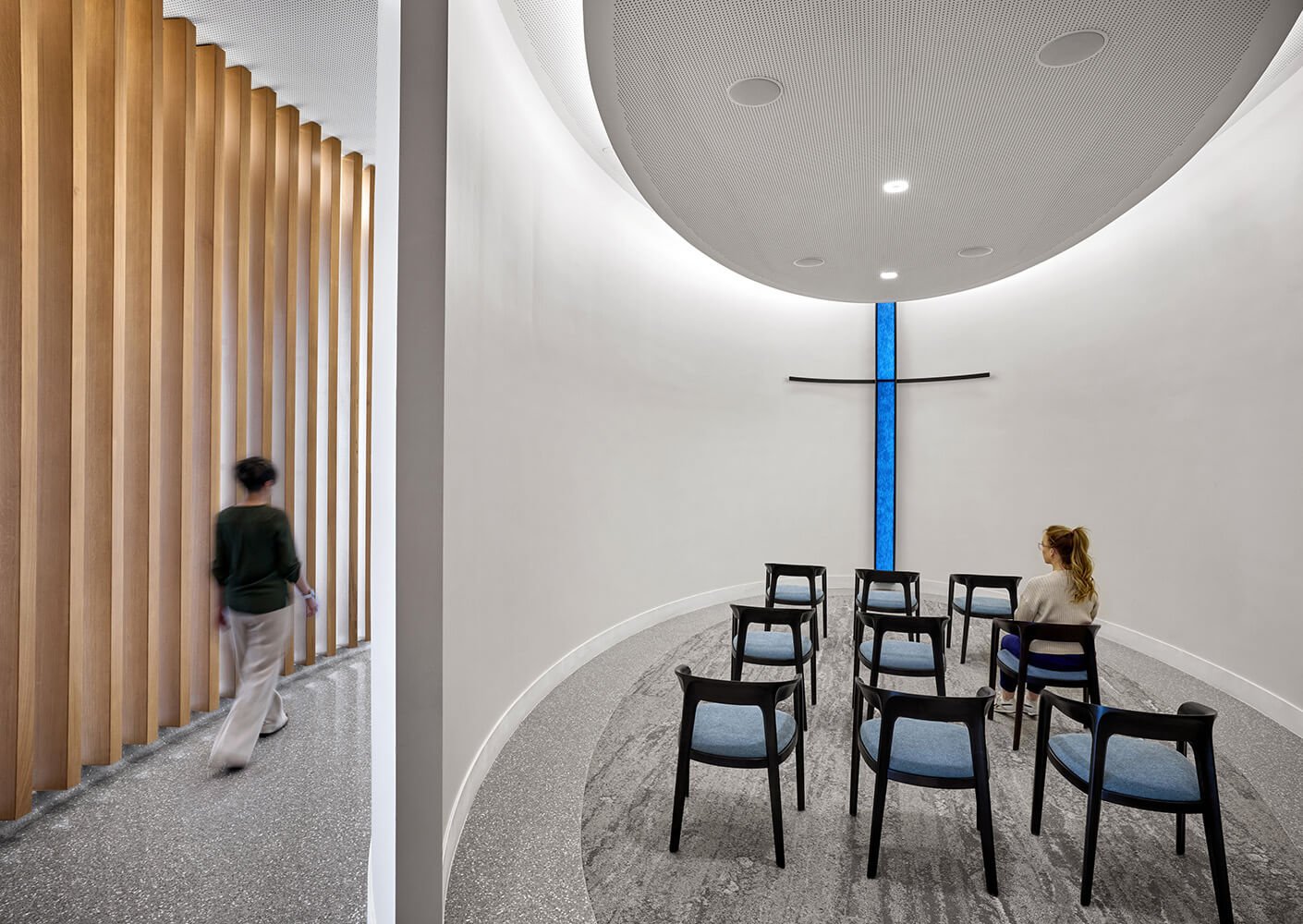 Bright, minimalist chapel interior with wooden accents, chairs, and diffused lighting