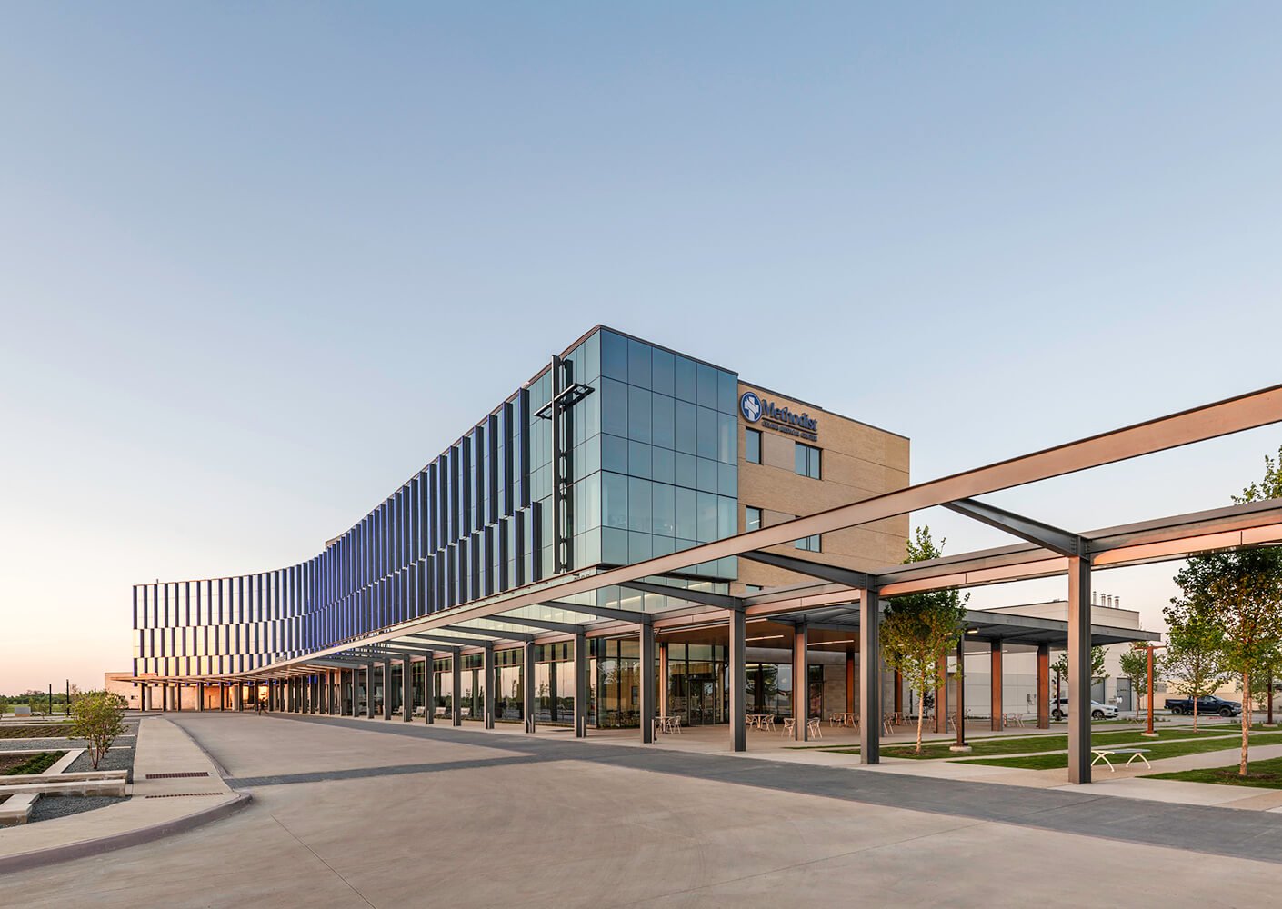 Modern glass hospital exterior at sunset
