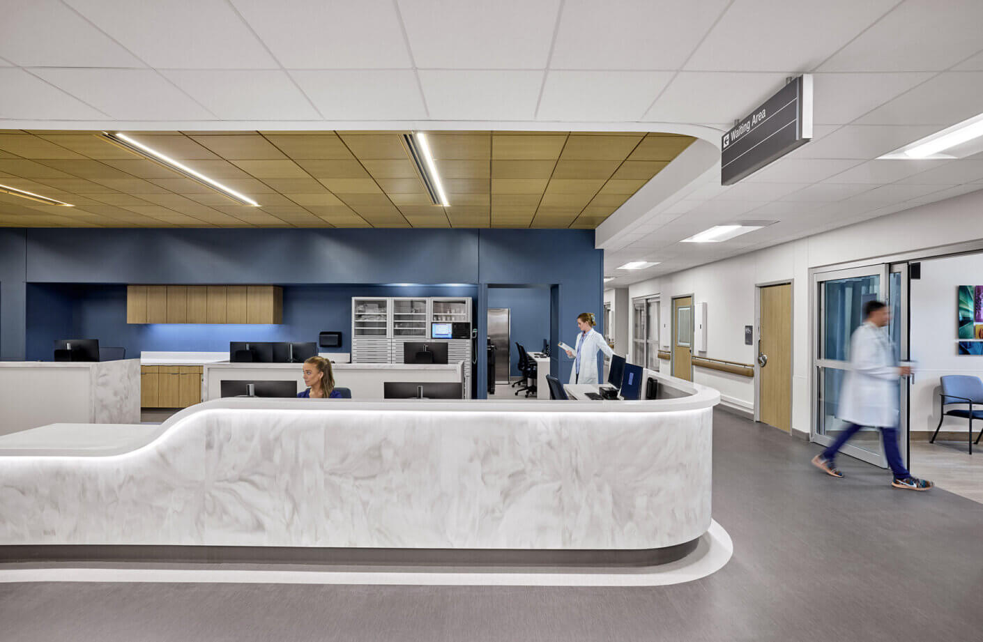 A nurses station with staff at work. Clean lines and blue backsplash.