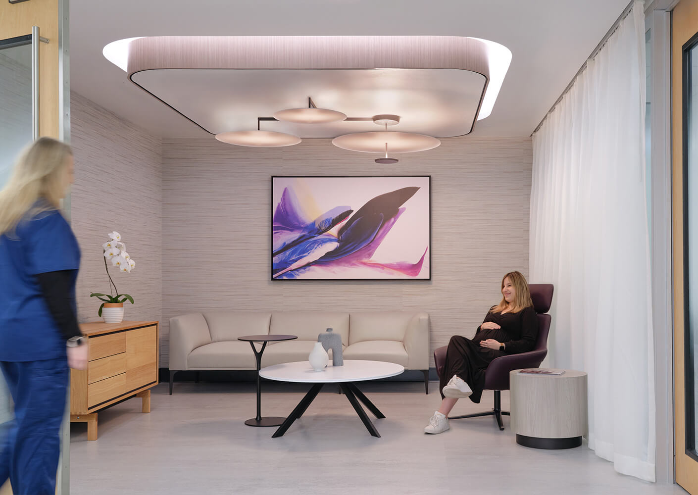 Modern waiting room with art, stylish furniture, and calming decor.