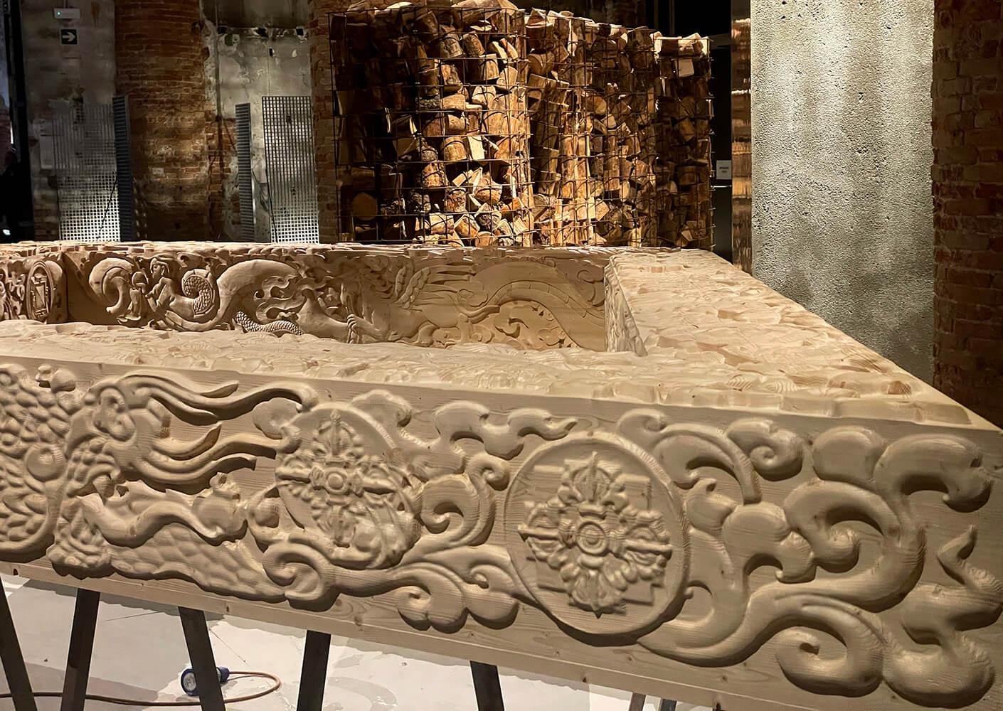 Ornate wooden sculpture with intricate carved designs in a dimly lit space.