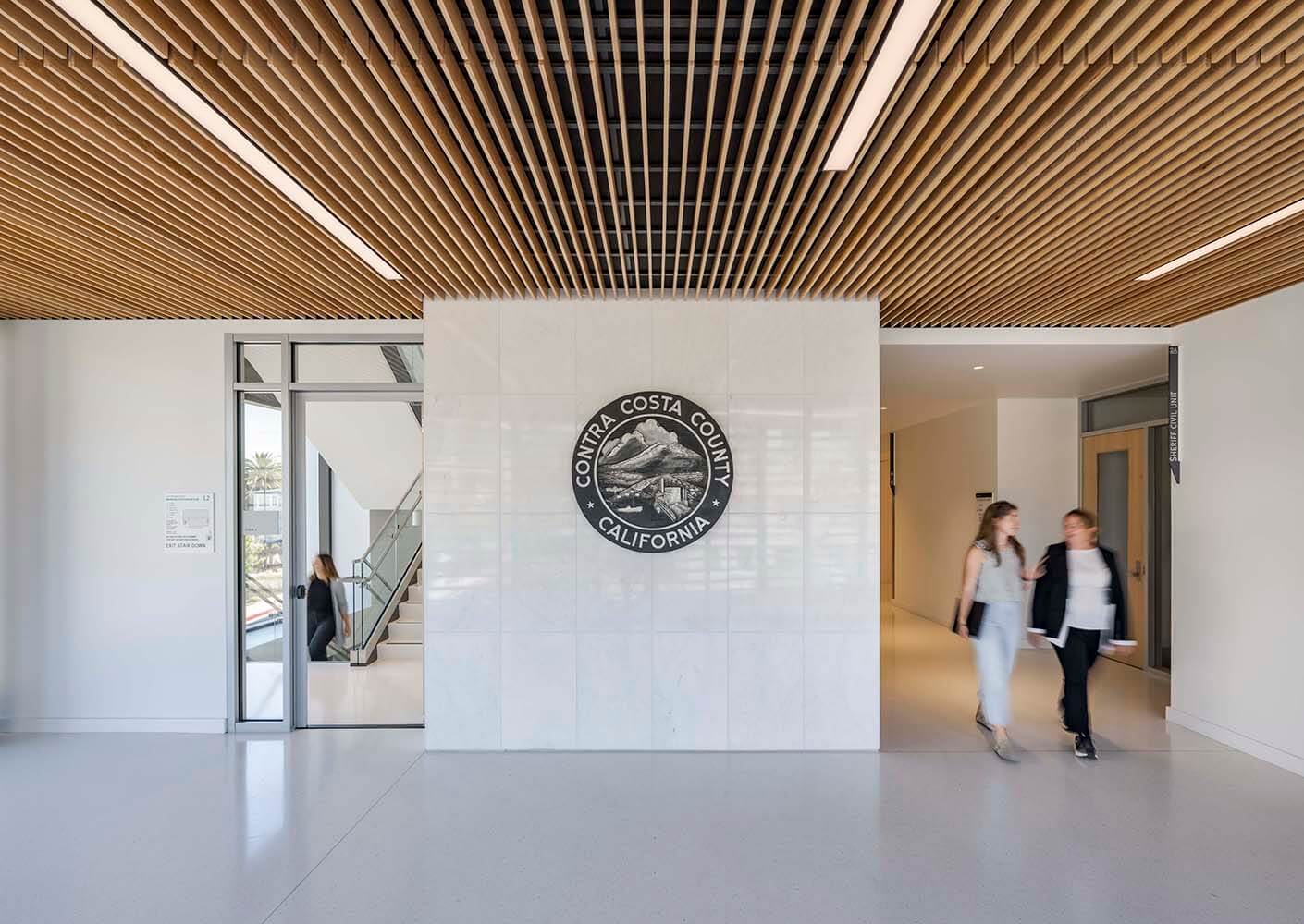 Contra Costa County building entrance with two people walking inside.