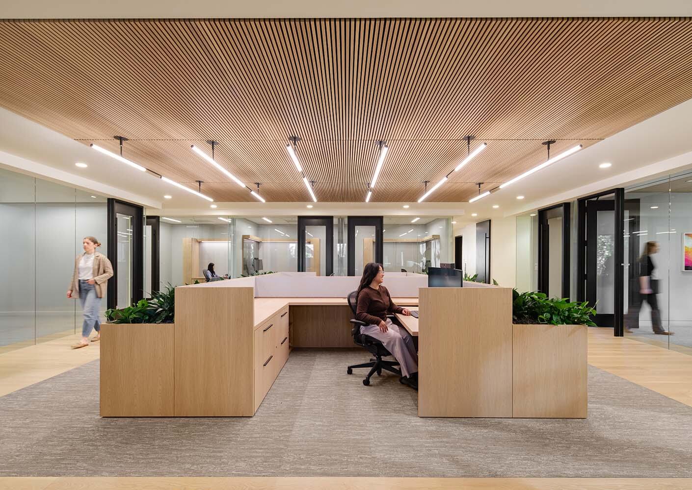 Modern office interior with wooden ceiling and people working.