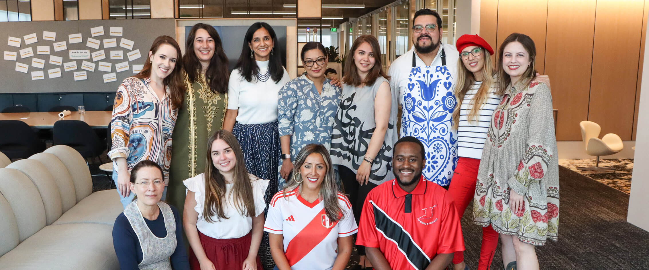 Diverse group of people smiling in a modern office lounge area.
