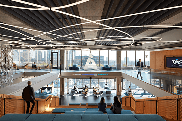 Modern office interior with open design, seating spaces, and city view.