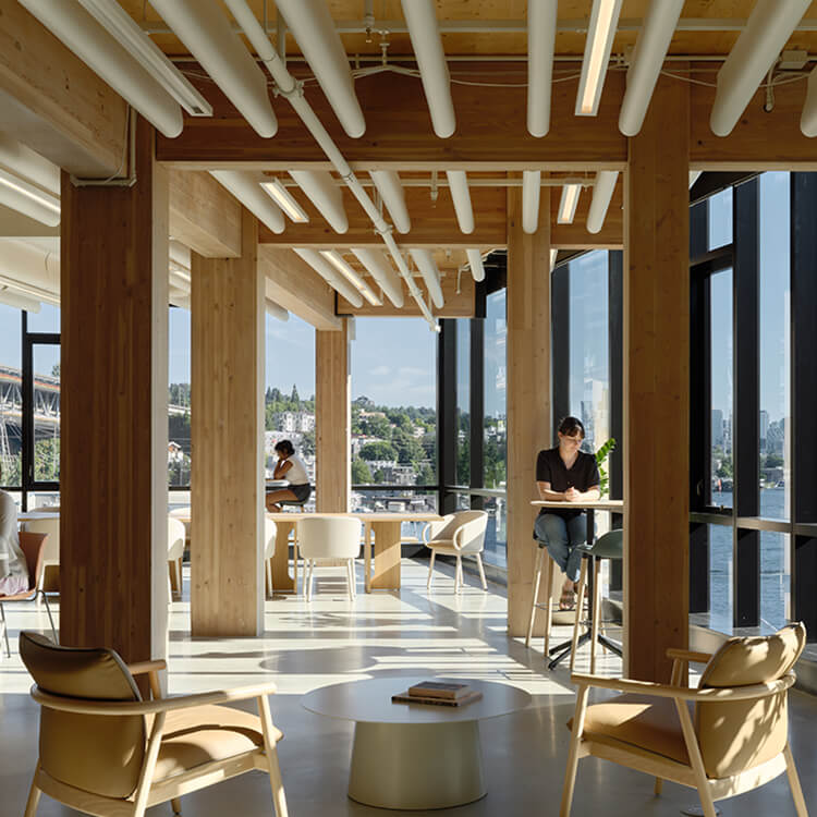 Modern office with wooden interiors and large windows overlooking a scenic city view.