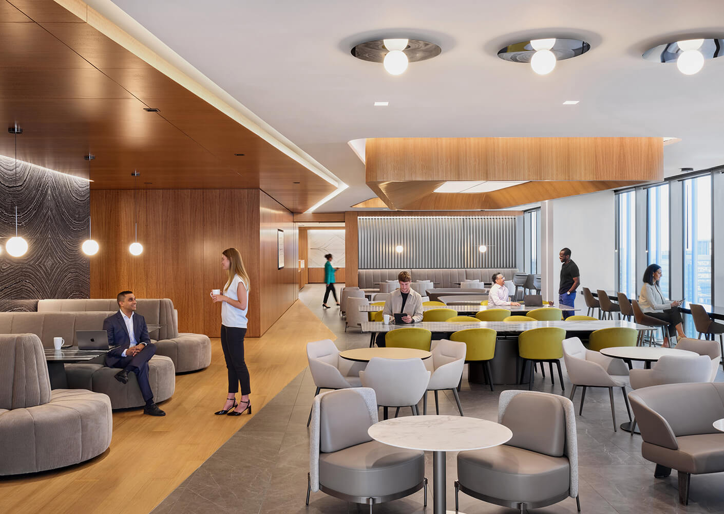 Modern office cafe and dining space with people working and conversing.