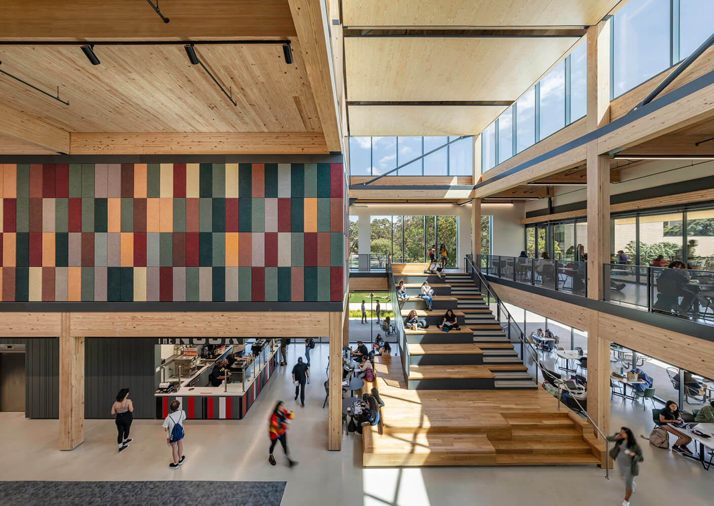 Modern, open-concept university common area with students studying and socializing.