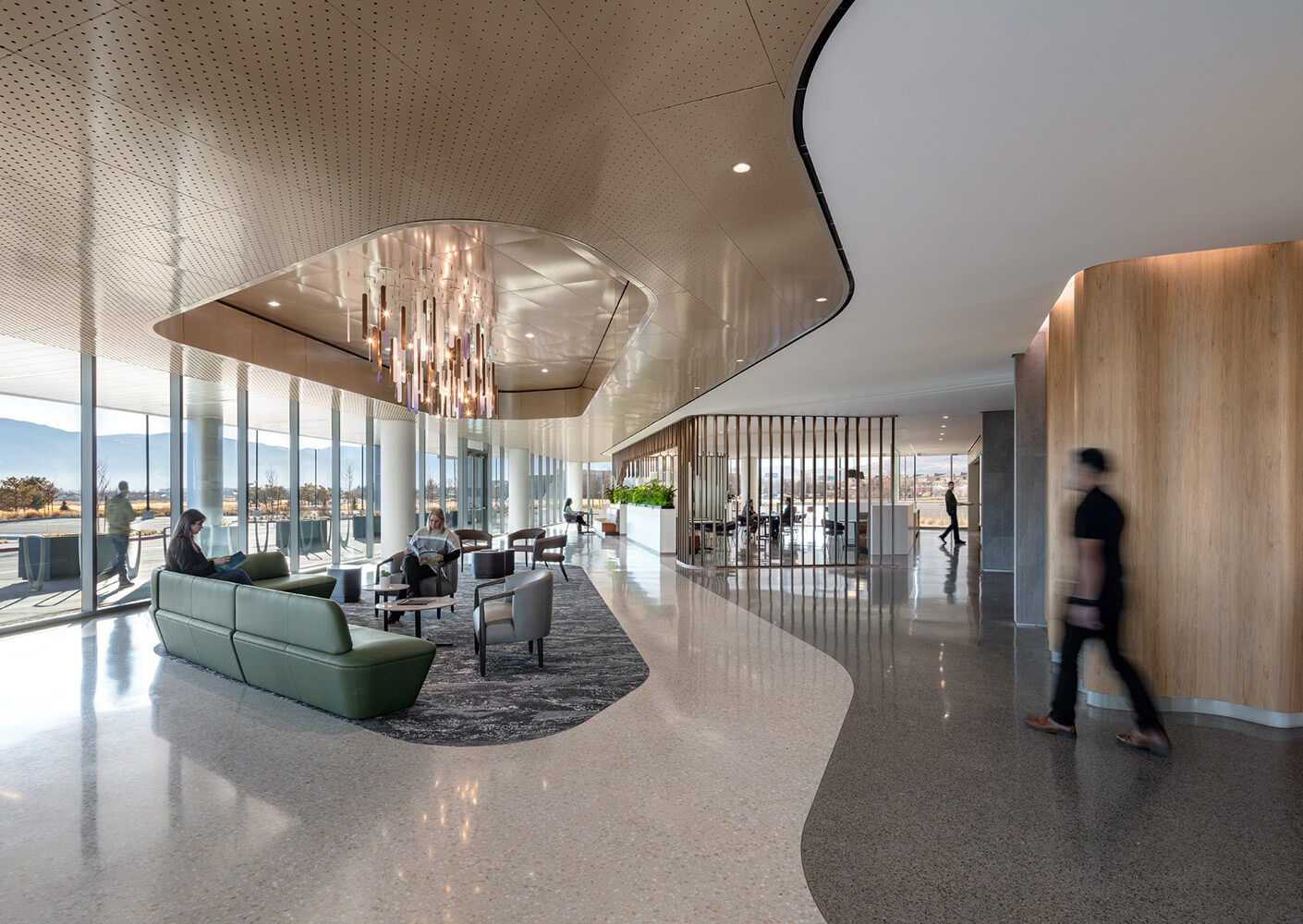 Modern lobby with elegant lighting, green sofas, and panoramic windows.